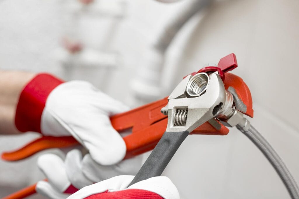 Plumber holding pipe wrenches for an emergency repair in Valrico