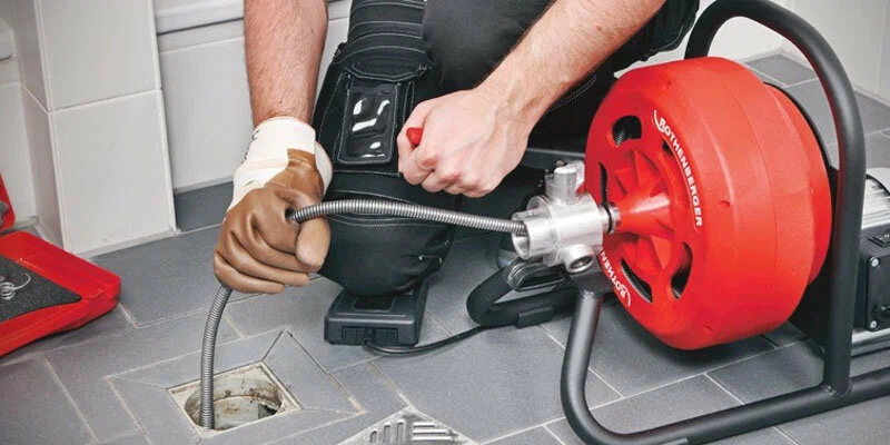 Plumber using a drain-cleaning machine in Valrico