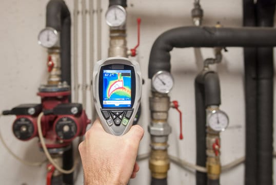 Plumber using a thermal imaging camera to inspect pipes in Valrico