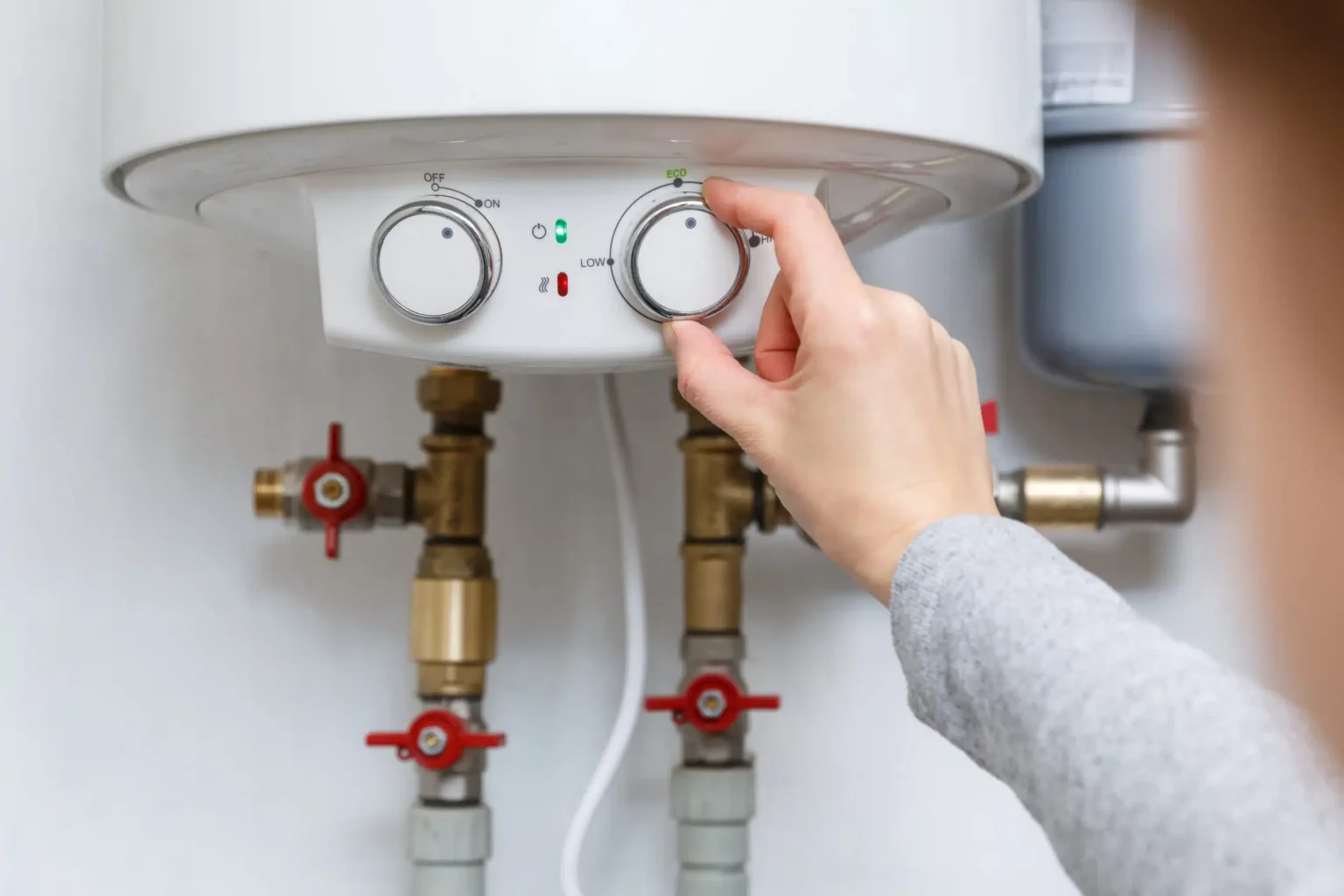Homeowner adjusting the temperature controls on a water heater in Valrico